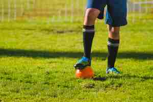 Photo gratuite le footballeur met son pied sur le ballon