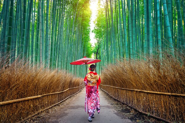 Foret de bambou. Femme asiatique portant un kimono traditionnel japonais à la forêt de bambous à Kyoto, au Japon.