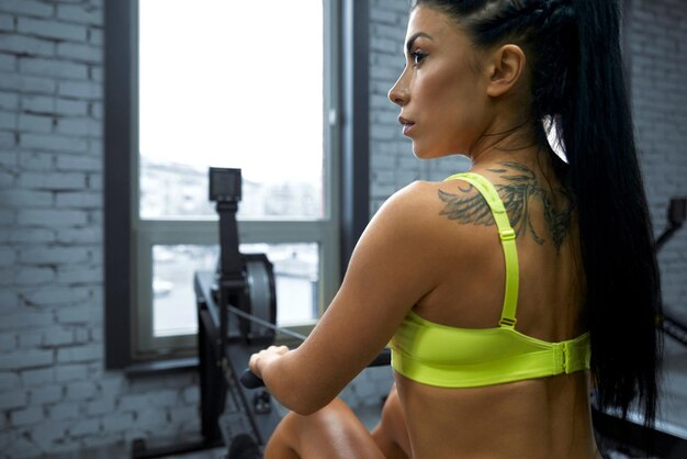 Formation de bodybuilder féminin dans la salle de gym