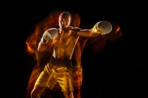 Formation de boxeur professionnel isolée sur fond de studio noir en lumière mixte