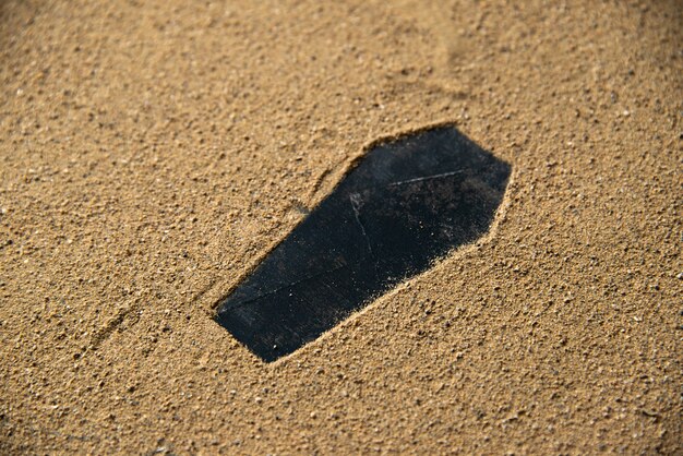 Forme de cercueil noir fait sur le sable