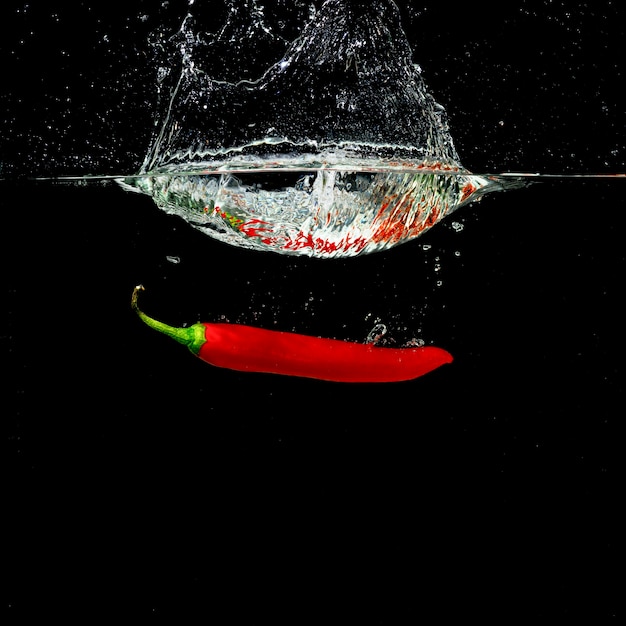 Forme d&#39;éclaboussure de couronne d&#39;eau par le piment rouge tombant dans l&#39;eau