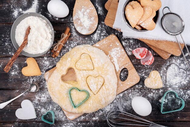 Formes de coeur Saint Valentin en pâte avec des ustensiles de cuisine