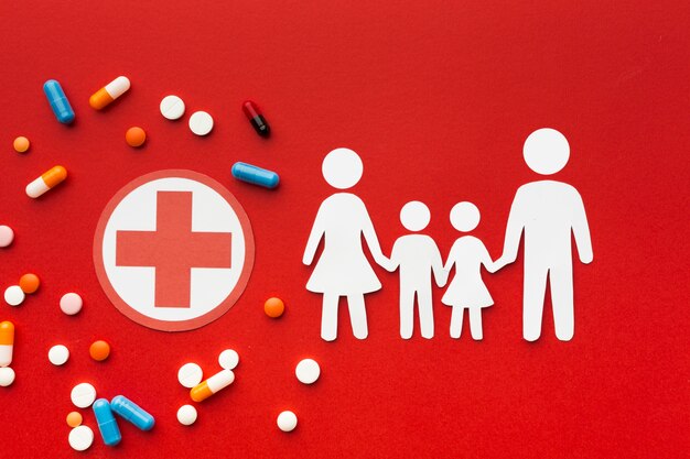 Formes de famille en carton avec des médicaments et symbole de la croix rouge