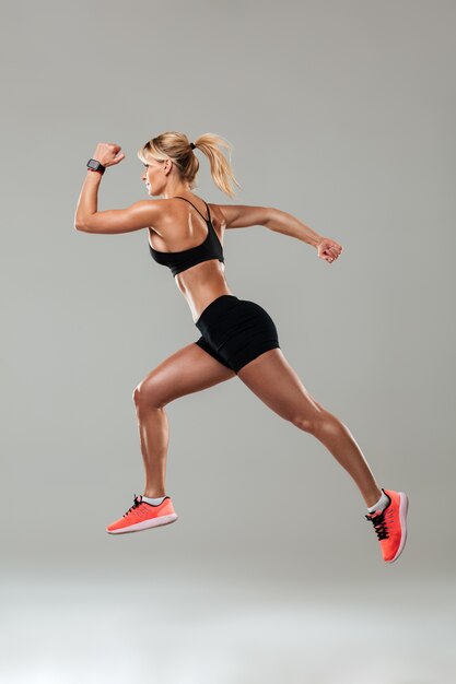 Forte jeune femme sportive courir isolé