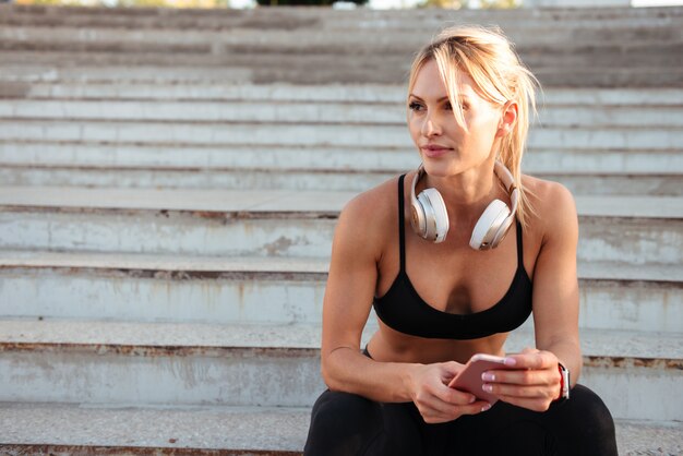 Forte jeune femme sportive discutant par téléphone