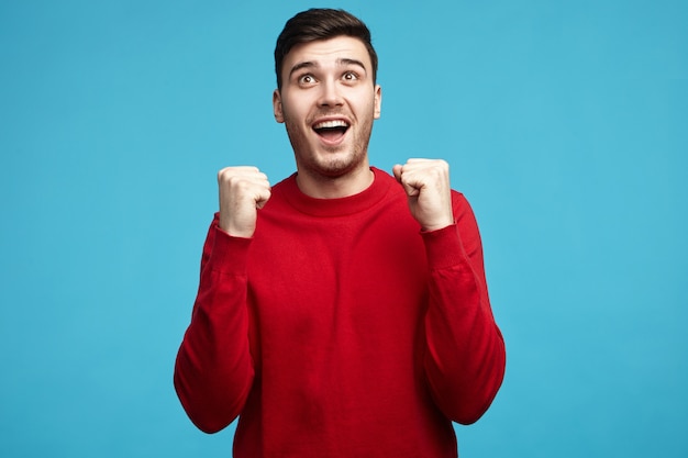 Fou de joie extatique heureux jeune homme de race blanche avec soies bénéficiant du succès