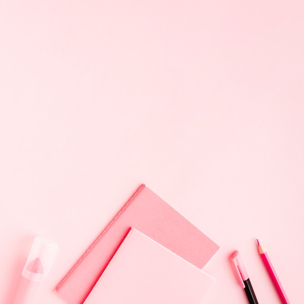 Fournitures de bureau roses sur une surface colorée