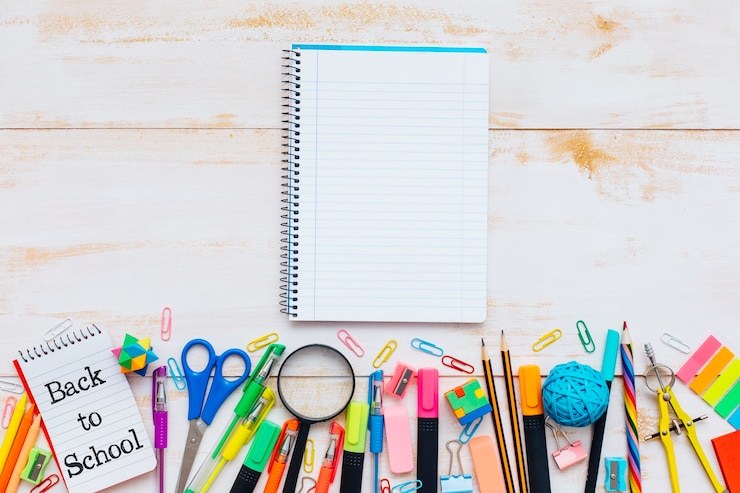 Photo gratuit fournitures scolaires et cahier sur fond de bois