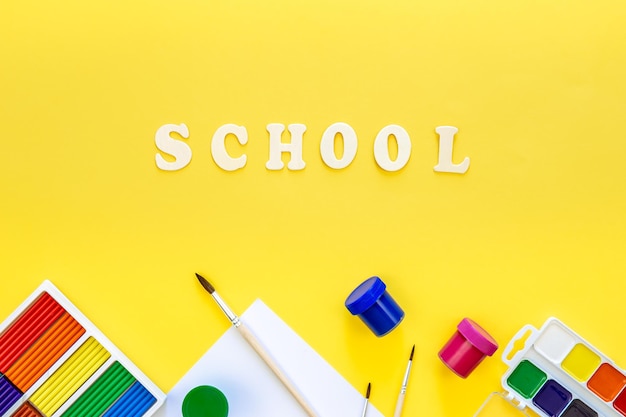 Photo gratuite fournitures scolaires colorées sur fond jaune retour à l'école concept vue de dessus