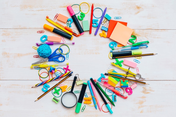Photo gratuit fournitures scolaires sur fond en bois blanc.