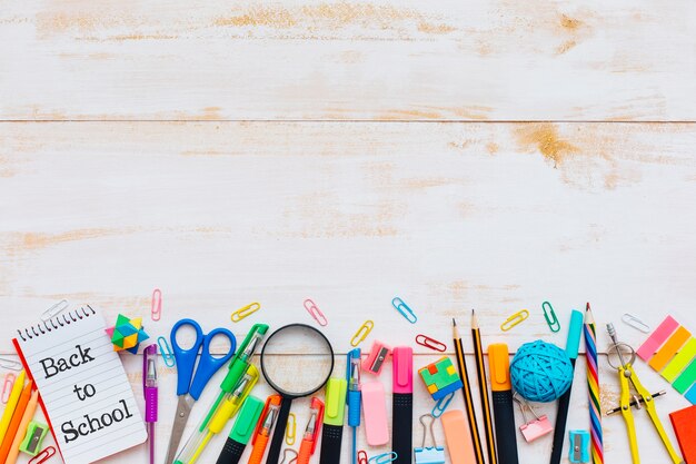 Fournitures scolaires sur une table en bois rustique.