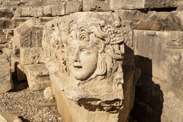 Fragment d'une frise avec masque en pierre sur les ruines de l'ancienne ville de mira, turquie