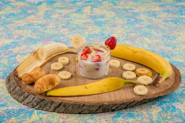 Fraises à la crème servies avec bananes et feuilletés