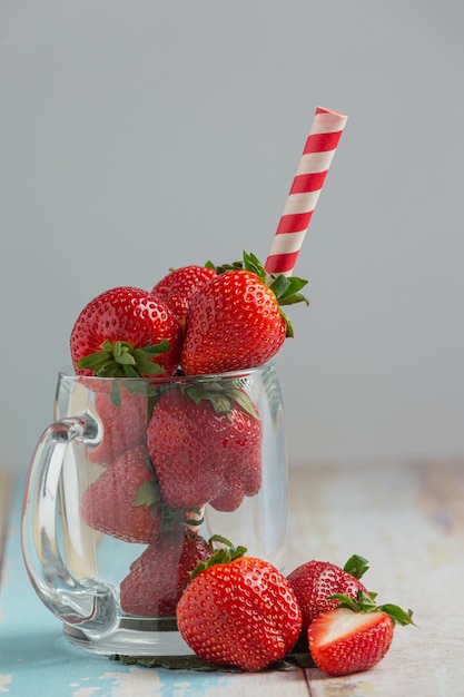 Fraises fraîches en verre sur table en bois