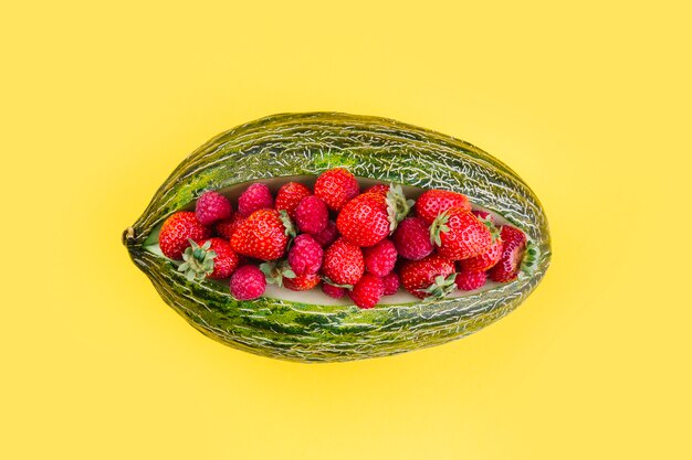 Fraises à l&#39;intérieur du melon vert sur fond jaune