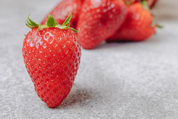 Fraises juteuses sur fond de béton