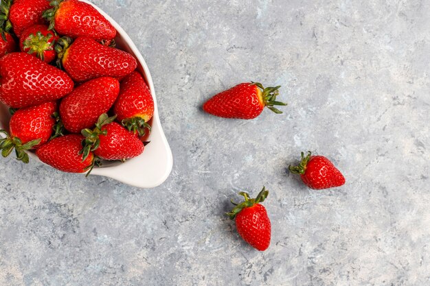 Fraises juteuses fraîches sur mur clair, vue de dessus