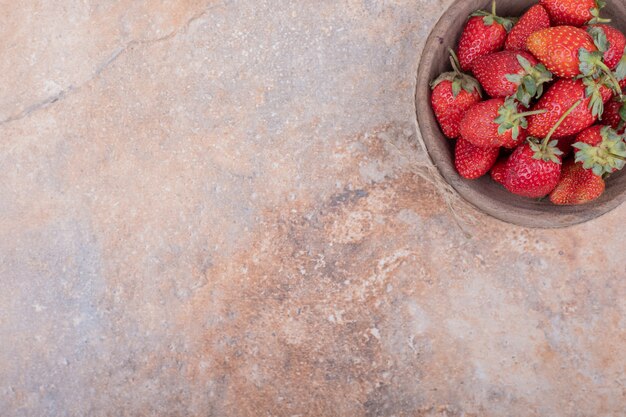 Photo gratuite fraises rouges dans un bol en bois rustique