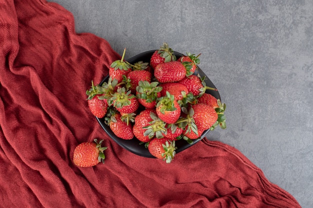 Fraises rouges fraîches dans un bol noir. photo de haute qualité