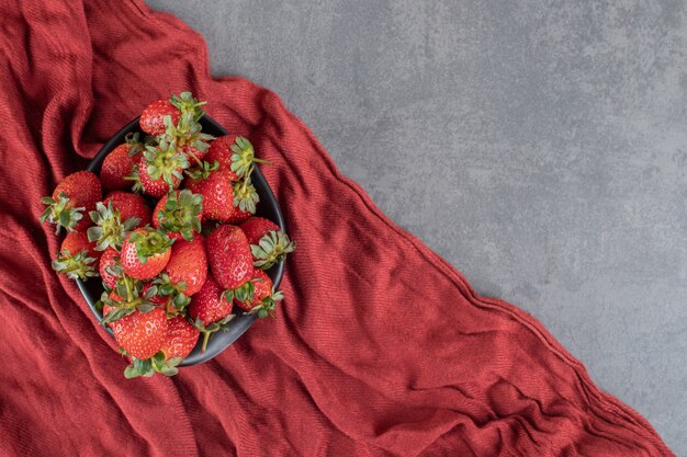 Fraises rouges fraîches dans un bol noir. photo de haute qualité