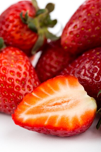 Fraises rouges frais mûrs moelleux isolé sur blanc bureau