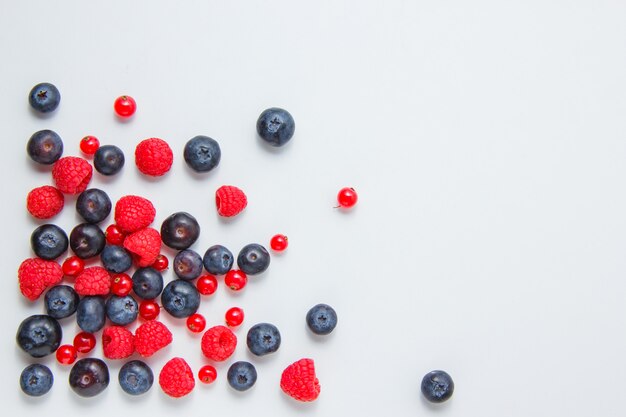 Framboises aux bleuets, groseilles vue de dessus sur fond blanc