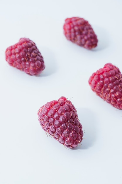 Framboises brillantes sur fond blanc