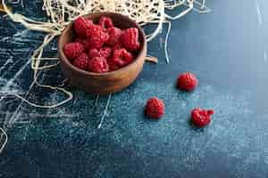 Photo gratuite framboises dans une tasse en bois.