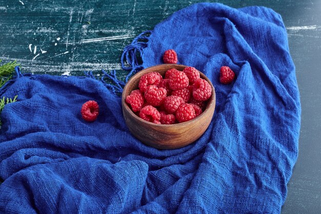 Framboises rouges dans un bol en bois.