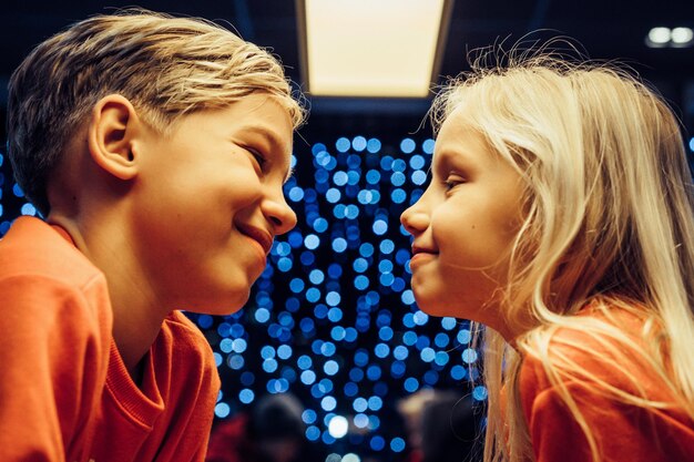 frère et soeur sur le fond d'une guirlande festive, lumières du Nouvel An, enfants.