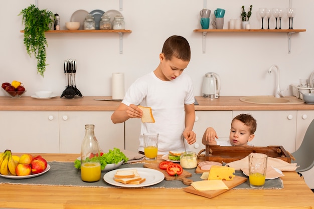 Photo gratuite frères à coup moyen avec de la nourriture à la maison