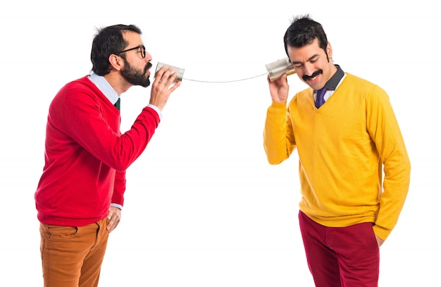 Des freres jumeaux parlent à travers un téléphone en étain