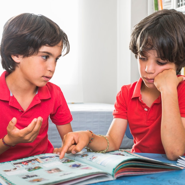 Photo gratuite frères parlant assis avec livre