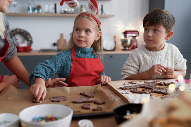 Frères et sœurs dans la cuisine à Noël