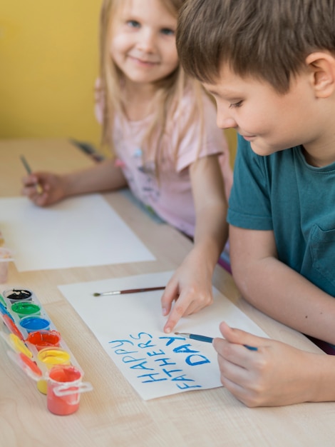 Frères et sœurs dessinant un cadeau pour leur père