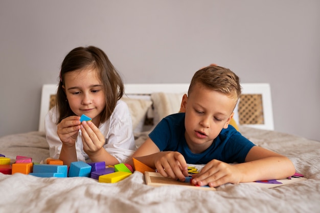 Photo gratuite frères et sœurs jouant avec des jouets casse-tête