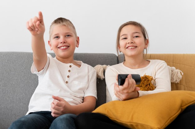 Frères et sœurs regardant la télévision ensemble