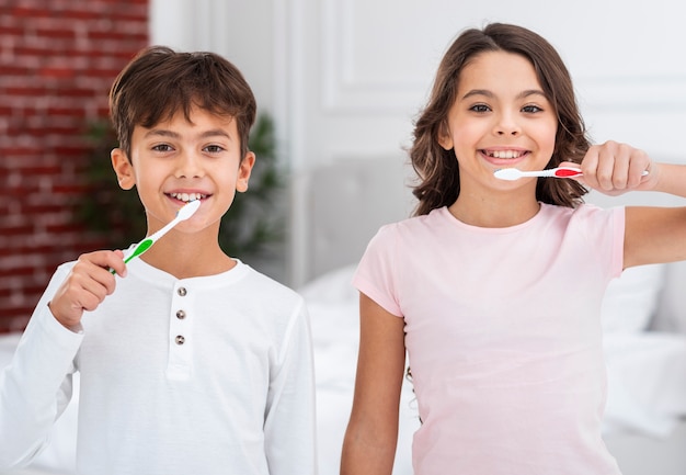 Frères et soeurs de la vue de face brosser les dents ensemble