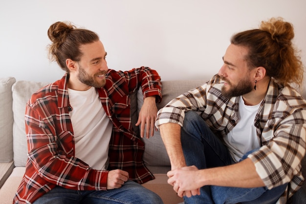 Frères souriants à coup moyen assis sur un canapé