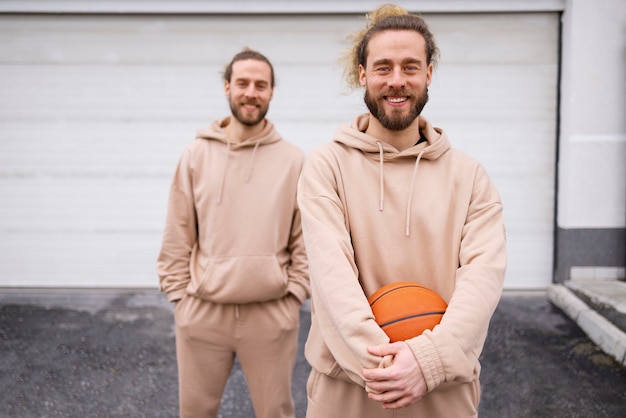 Photo gratuite frères souriants vue de face avec basket-ball