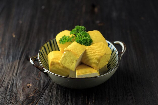 Fresh made raw bean curd bandung tofu jaune cube de coupe sur table en bois (tahu susu lembang). concept de repas sain végétalien. copiez l'espace pour la publicité, le texte ou la recette