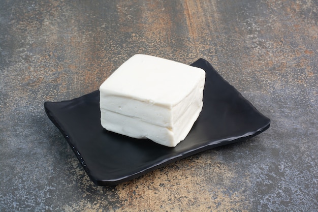 Fromage blanc naturel sur plaque noire.