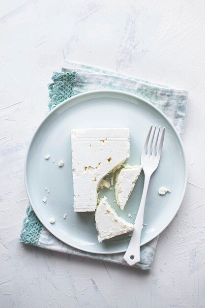 Fromage feta sur une plaque blanche avec une fourchette à plat