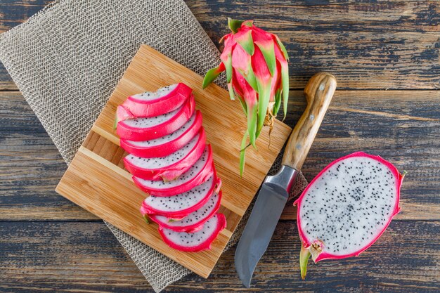 Fruit du dragon avec planche à découper, couteau plat posé sur table en bois