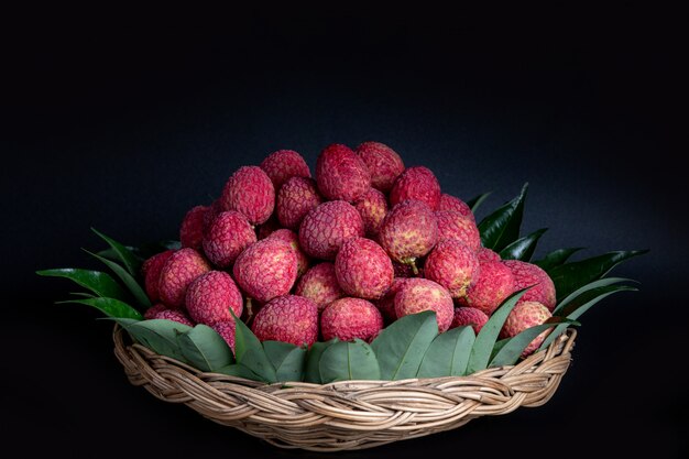 Fruit de litchi rouge placé dans un panier.