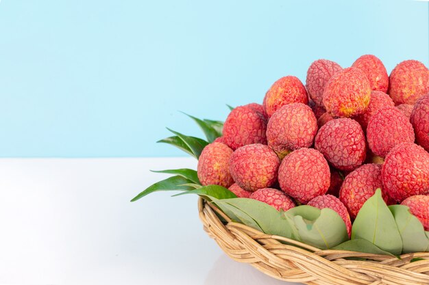 Fruit de litchi rouge placé dans un panier.