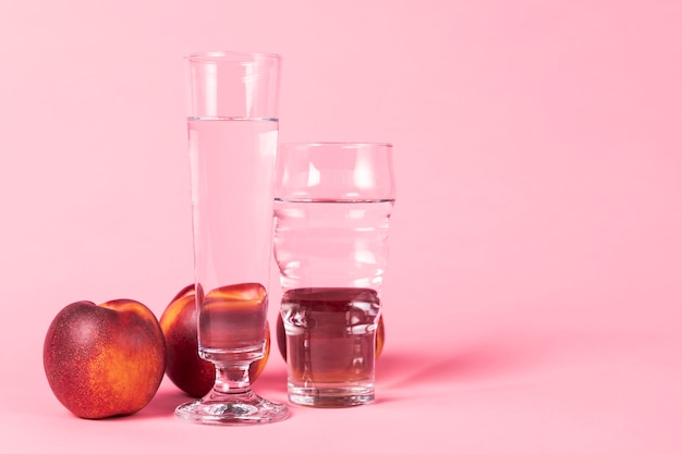 Photo gratuite fruit nectarine et verres d'eau