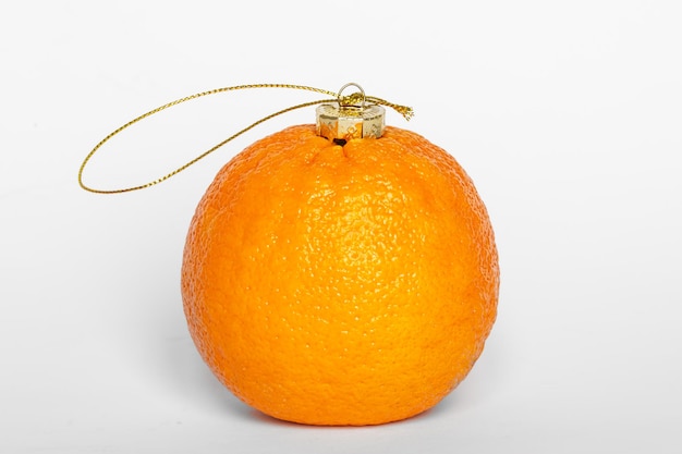 Fruit orange comme boule de Noël isolé sur fond blanc