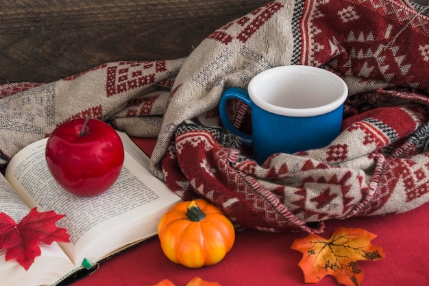 Photo gratuite fruits artificiels sur livre près de la couverture et de la tasse